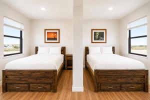 two beds in a room with two windows at The Resource Inn Big Lake in Big Lake