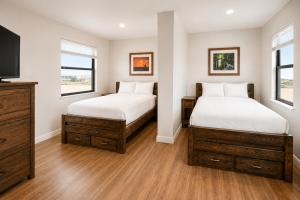two beds in a room with two windows at The Resource Inn Big Lake in Big Lake