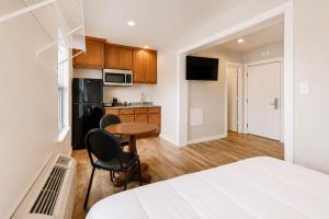 a bedroom with a bed and a kitchen with a table at The Resource Inn Big Lake in Big Lake +34 photos