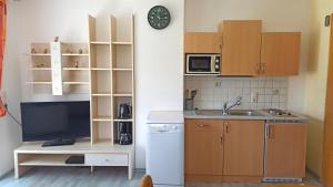 a kitchen with a sink and a clock on a wall at Villa Rupi in Sankt Ulrich am Pillersee