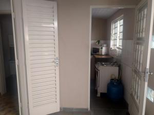 a hallway with a door leading into a kitchen at Suites-II no centro de Salto SP in Salto