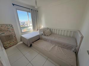 a small bedroom with two beds and a window at Apartment in Ponta Negra in Manaus +34 photos