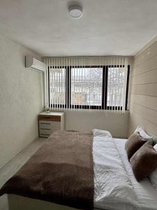 a bedroom with a large bed and two windows at Хижа Оборище in Oborishte