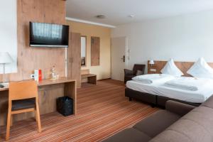a hotel room with a bed and a desk at Gasthaus zur Krone in Weingarten (Karlsruhe)