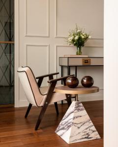 a living room with a chair and a table at Villa Costanza Boutique Hotel in Forte dei Marmi