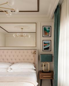 a bedroom with a white bed and a chandelier at Villa Costanza Boutique Hotel in Forte dei Marmi
