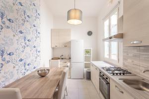 a kitchen with a wooden table and a counter top at Verdi 185 by Pleiades Home in Livorno