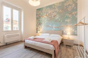 a bedroom with a bed and a floral wall at Verdi 185 by Pleiades Home in Livorno