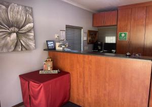 a kitchen with a bar with a red table at Travel Lodge in Middelburg