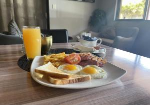 a plate of eggs and toast and a glass of orange juice at Travel Lodge in Middelburg