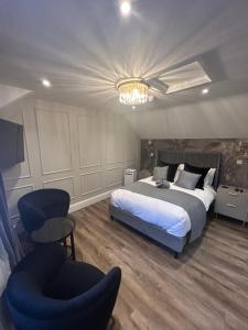 a bedroom with a bed and a chair and a chandelier at The Mill Sharnbrook - Bedford in Sharnbrook +45 photos