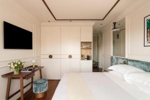 a bedroom with a large white bed and a table at Villa Costanza Boutique Hotel in Forte dei Marmi