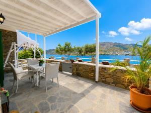 a patio with a table and chairs and a view of the water at Astrio Suites in Livadi