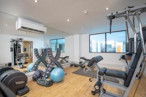 a gym with several treadmills and exercise machines at Belgrave Sands Hotel & Spa in Torquay