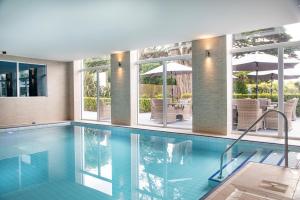 a swimming pool with chairs and an umbrella at Belgrave Sands Hotel & Spa in Torquay