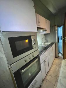 a kitchen with a stove and a microwave at RÉSIDENCE IDM-Ngoma in Kinshasa