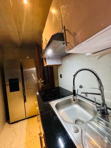a kitchen with a sink and a stove at RÉSIDENCE IDM-Ngoma in Kinshasa +17 photos