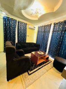 a living room with a black couch and a table at RÉSIDENCE IDM-Ngoma in Kinshasa