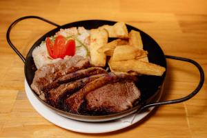 a plate of food with meat and french fries at casa de esteban in Puerto Iguazú