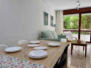 a dining room table with plates and glasses on it at Apartamento Playa Azul - 5924 in Arnuero