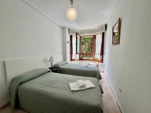a bedroom with two beds and a window at Apartamento Playa Azul - 5924 in Arnuero +9 photos