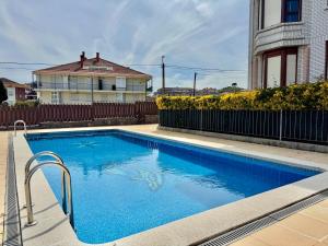 a blue swimming pool in front of a house at Apartamento Playa Azul - 5924 in Arnuero