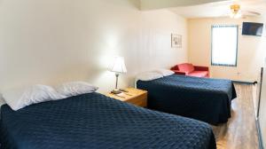 a hotel room with two beds and a red chair at Sunrise Motel in Seaside Heights +40 photos