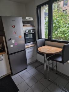 a kitchen with a refrigerator and a table and a window at Hortillonne in Amiens