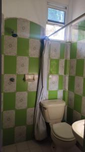 a green and white bathroom with a toilet and a sink at Jungle Palace hostal santaella in Puerto Escondido +92 photos