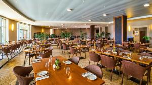 a restaurant with wooden tables and chairs at Radisson Blu Resort & Spa, Malta Golden Sands in Mellieħa