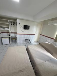 a living room with a bed and a kitchen at Hotel Ideal in Teresina