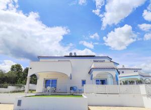 a white house with a fence in front of it at Villetta Borgo Bianco 1 con piscina in condivisione in Budoni