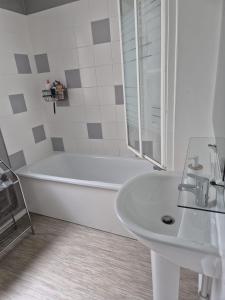 a white bathroom with a tub and a sink at Hortillonne in Amiens