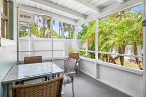 a balcony with a table and chairs and palm trees at A Place in Paradise Unit B in Anna Maria