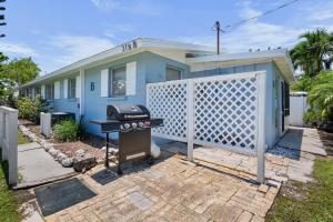 a barbecue grill in front of a blue house at A Place in Paradise Unit B in Anna Maria