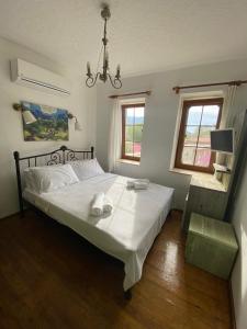 a bedroom with a bed with white sheets and a chandelier at Just Datça in Datca