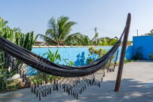 a hammock in front of a swimming pool at Portal de Búzios in Armacao dos Buzios
