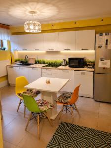 a kitchen with a white table and chairs at Apartament Biała Flaga Podwórko, Grill, Rowery in Charzykowy