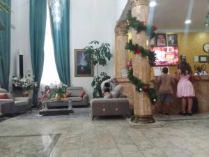 a group of people standing in a living room with a christmas tree at Bougainvillea Hotels in Port Harcourt