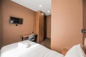 a hotel room with two beds and a desk at MIRAFI Hotel in Almaty