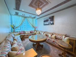 a living room with a couch and a table at Abraj Dubai - Premium 3BR Stay in Heart of Larache in Larache
