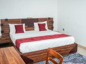 a bedroom with a large bed with a wooden headboard at Bougainvillea Hotels in Port Harcourt