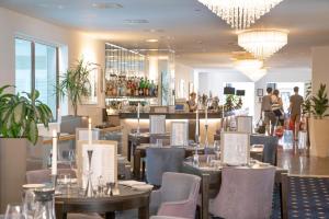 a restaurant with tables and chairs and a bar at Belgrave Sands Hotel & Spa in Torquay