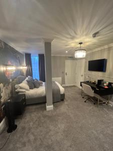 a bedroom with a bed and a desk and a television at The Mill Sharnbrook - Bedford in Sharnbrook