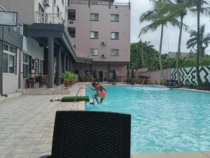 a woman is playing in a swimming pool at Bougainvillea Hotels in Port Harcourt +10 photos