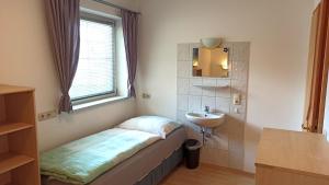a small bathroom with a bed and a sink at Villa Rupi in Sankt Ulrich am Pillersee
