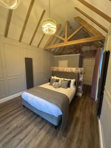 a bedroom with a bed in a room with wooden floors at The Mill Sharnbrook - Bedford in Sharnbrook