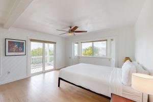 a white bedroom with a bed and two windows at CJ295FLR Hawkins Lookout in Cudjoe Key