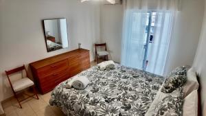 a bedroom with a bed and a dresser and a mirror at Casa Inês in Fuzeta