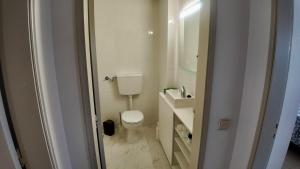 a white bathroom with a toilet and a sink at Casa Inês in Fuzeta +14 photos